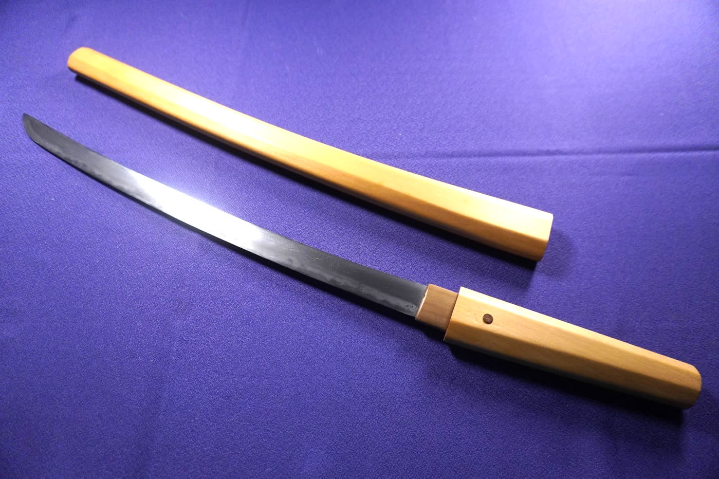 Wakizashi Study III wakizashi drawn from its plain wooden shirasaya on purple cloth