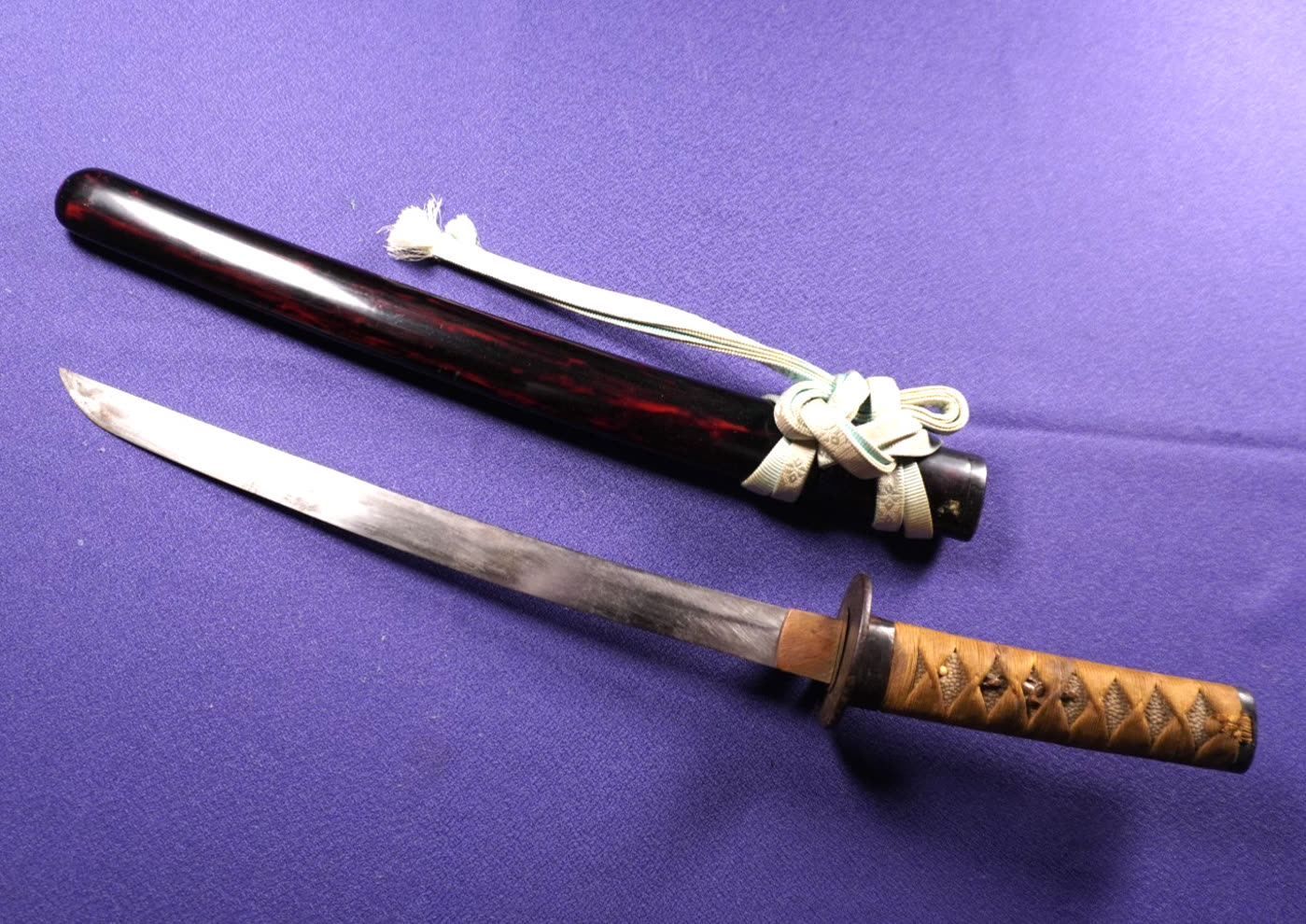 Hira-zukuri wakizashi drawn beside its red-and-black marbled lacquer saya